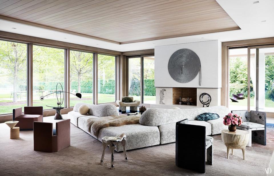 A sofa by Francesco Binfaré with pillows by Zak + Fox and Martyn Thompson Studio spreads across the expansive living room. 1960 artwork (far left) atop Arteriors side table; others by Alice Hope, Diego Cabezas, Joel Perlman, and Pamela Sunday.
