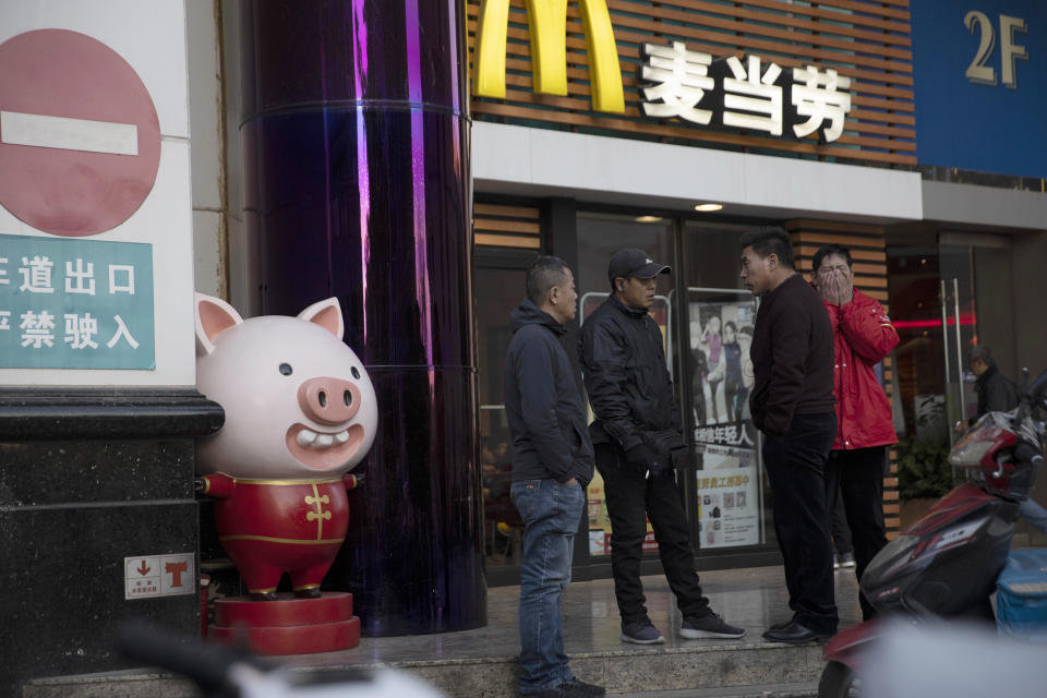 Workers gather outside a mall in Beijing on Friday, Oct. 25, 2019. The discovery in England of the bodies of 39 people believed to be from China lays bare some crucial but sometimes overlooked facts about China's development as a rising global power that has elevated hundreds of millions of its citizens to the middle classes. (AP Photo/Ng Han Guan)