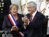 Chile's President Michelle Bachelet (L) and outgoing President Sebastian Pinera applaud after Bachelet was sworn in to office in Valparaiso, March 11, 2014. REUTERS/Maglio Perez