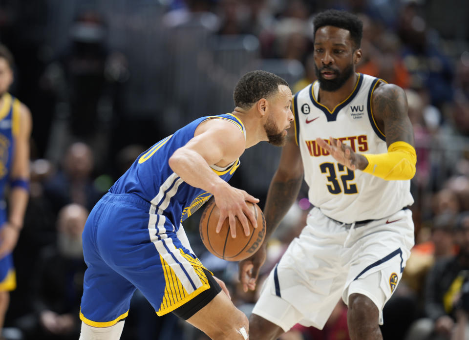 Golden State Warriors guard Stephen Curry, left, drives to the basket as Denver Nuggets forward Jeff Green defends in the first half of an NBA basketball game Sunday, April 2, 2023, in Denver. (AP Photo/David Zalubowski)