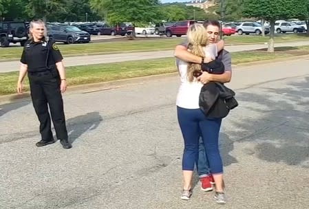 People embrace after being evacuated from a building by police in this still image taken from video following a shooting incident at the municipal center in Virginia Beach