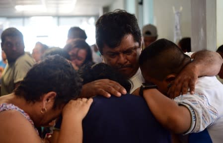 People react as they wait for the news about their relatives after an arson attack by suspected gang members on a bar "El Caballo Blanco" in the southern Mexican port of Coatzacoalcos