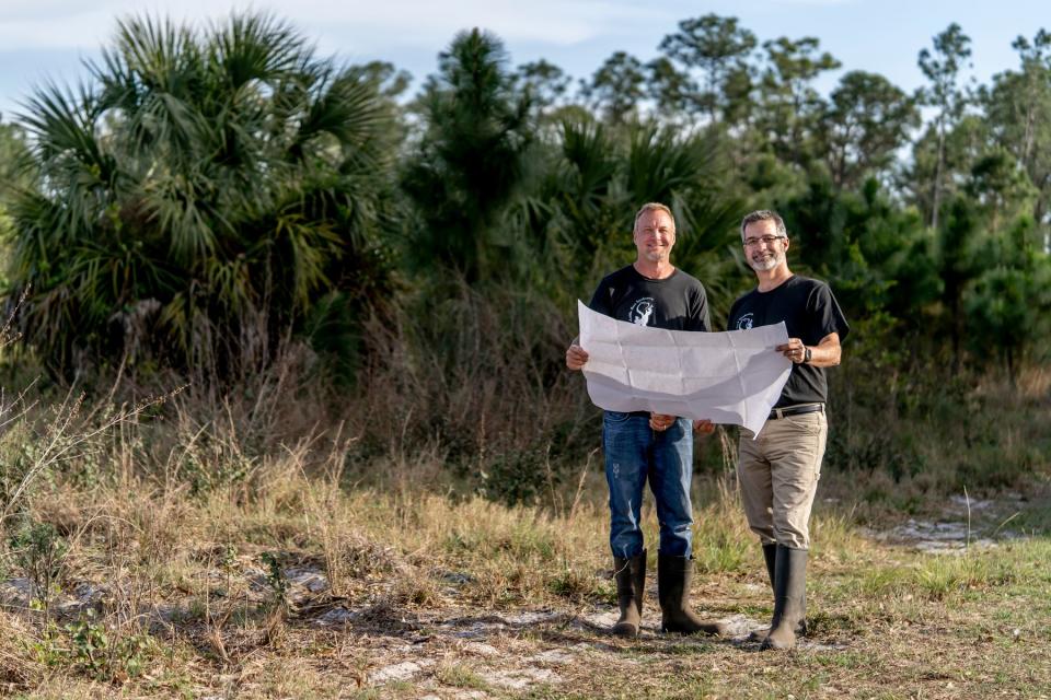 Two men hold plans. (GoFundMe Heroes)