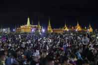 Pro-democracy demonstrators attend a protest at Sanam Luang with The Grand Palace lit up in the background in Bangkok, Thailand, Saturday, Sept. 19, 2020. Thousands of demonstrators turned out Saturday for a rally to support the student-led protest movement's demands for new elections and reform of the monarchy. (AP Photo/Sakchai Lalit)