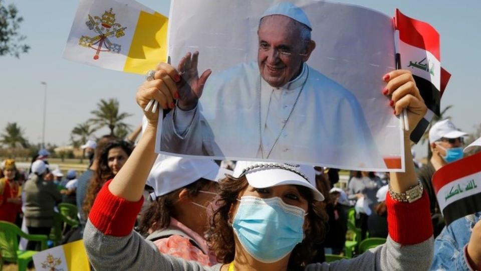 Mujer con foto del Papa fuera del aeropuerto de Bagdad el viernes 5 de marzo de 2020.