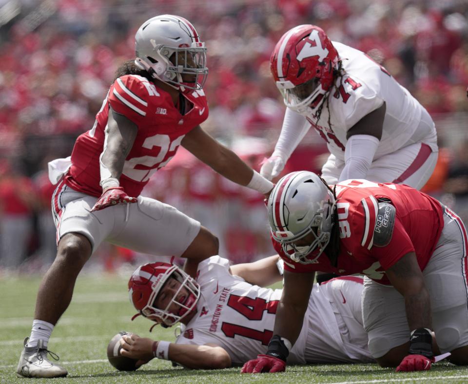 Youngstown State quarterback Mitch Davidson is taken down by Ohio State linebacker Steele Chambers (22) and defensive tackle Jaden McKenzie on Sept. 9.