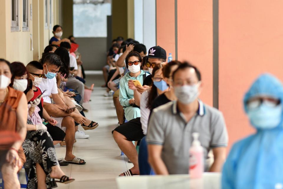 Residents wait to be tested at a makeshift rapid testing centre as Vietnam records a rise in cases of the COVID-19 coronavirus in Hanoi on July 31, 2020.