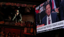 <p>JUN. 8, 2017 – A bar patron at Ace’s Bar in San Francisco, watches a television broadcast as former FBI Director James Comey testifies before the Senate Intelligence Committee. People across the country are flocking to bars and restaurants to watch former FBI director as he testifies before the Senate Intelligence Committee about his conversations with U.S. President Donald Trump. (Photo: Justin Sullivan/Getty Images) </p>