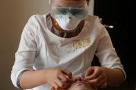 Beautician wearing protective mask and goggles attends to a customer with facial mask during treatment at the Pearl Deluxe beauty spa as the country is hit by an outbreak of the novel coronavirus, in Beijing