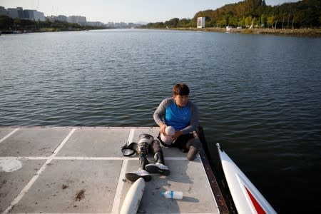 Former South Korean Army sergeant Ha Jae-hun, who lost both his legs in 2015 when he stepped on a North Korean landmine while on a patrol in the DMZ, puts on his artificial legs after a practice session at Misari Rowing Stadium in Hanam, South Korea