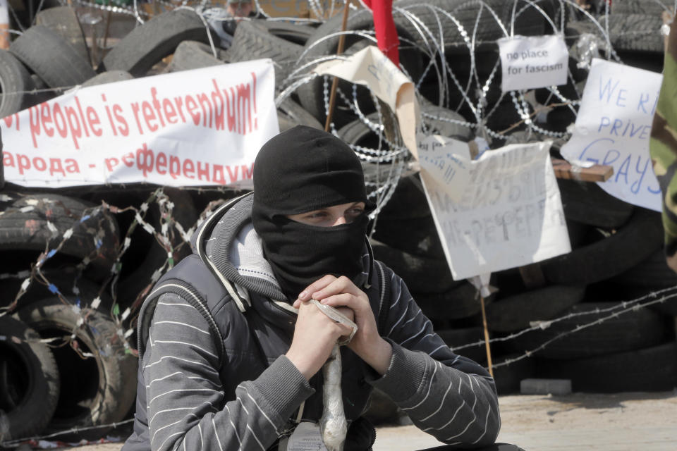 A masked pro-Russian activist guards a barricade at the regional administration building that they had seized earlier in Donetsk, Ukraine, Tuesday , April 15, 2014. Several government buildings have fallen to mobs of Moscow loyalists in recent days as unrest spreads across the east of the country. (AP Photo/Efrem Lukatsky)