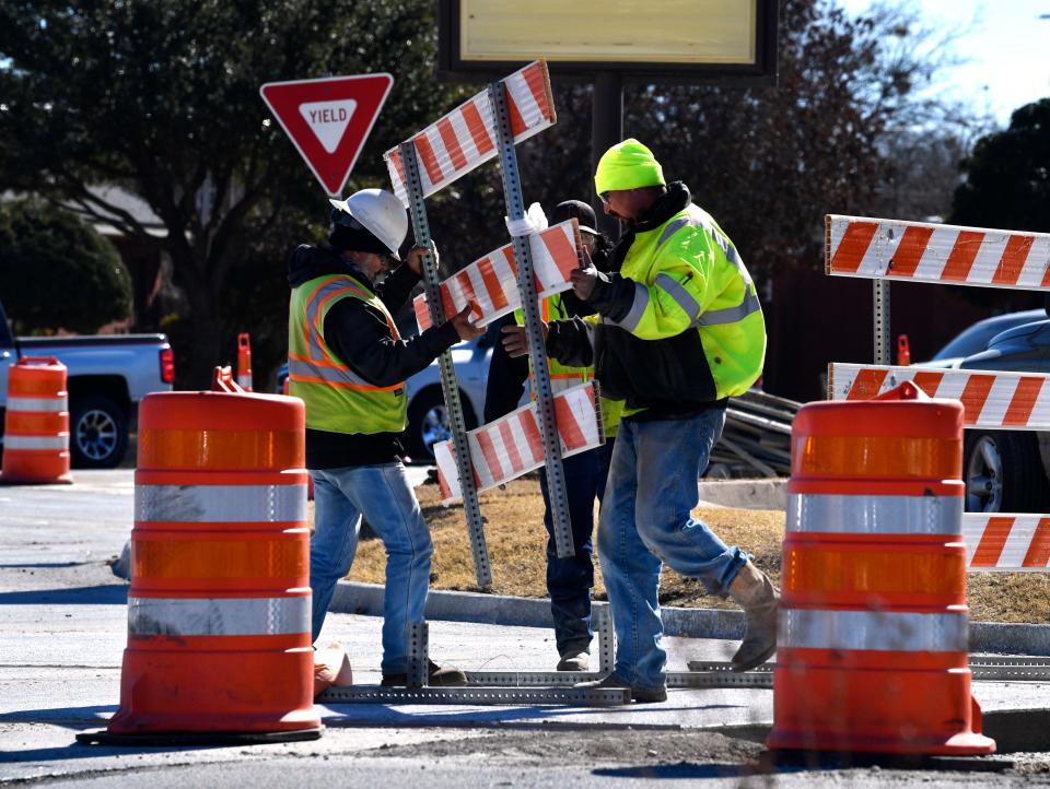 Workmen move a warning sign at the intersection of South 27th Street and Buffalo Gap Road on Friday. Work began Jan. 10 and is expected to take two months for completion.