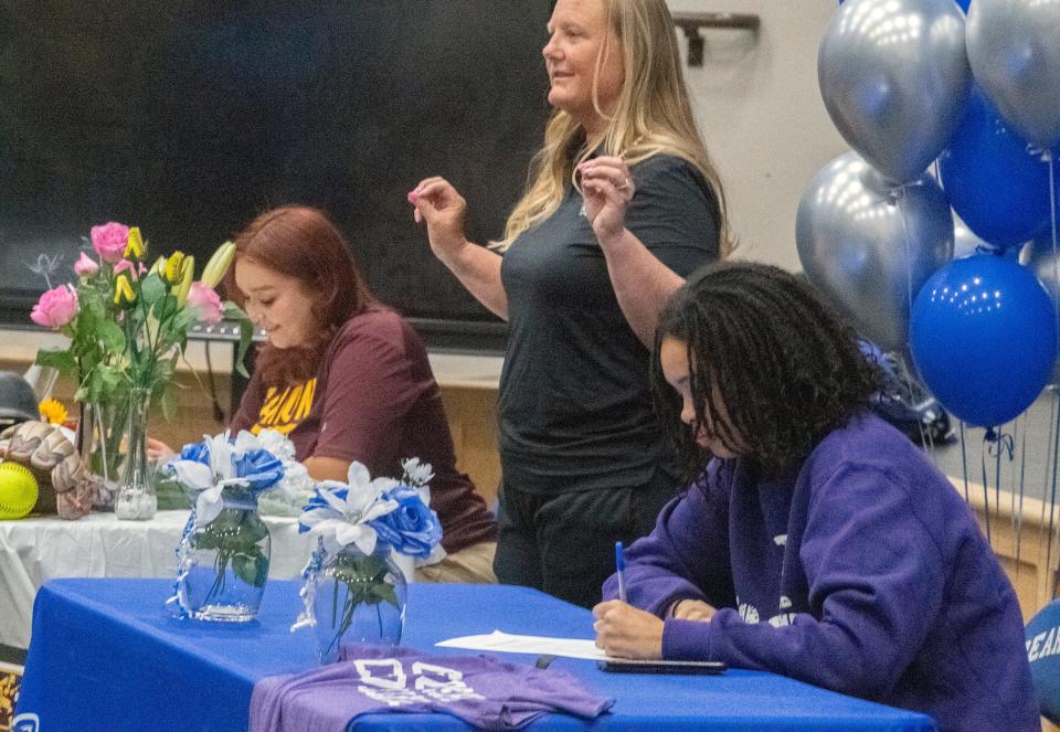 Bear Creek's Destiny Garcia, left, and Armani Guidry, with athletic director Darcy Altheide, center, participate in a signing ceremony at the school Stockton. Garcia will play softball for Gannon University and Guidry has committed to play volleyball for Goshen College.