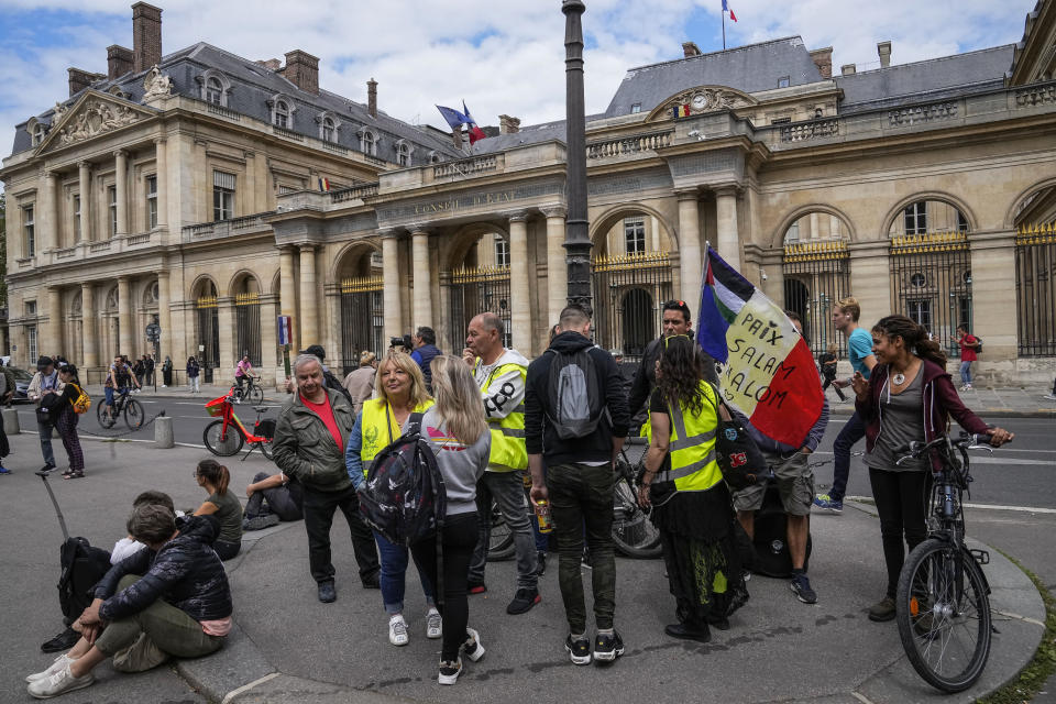 Anti heath pass demonstrators stage a protest outside the Constitutional Council in Paris, Thursday, Aug. 5,2021. France's Constitutional Council is deciding on Thursday whether the health pass that is to open the doors and terraces to cafes, restaurants, trains and hospitals starting next week is in line with the nation's most cherished principles. (AP Photo/Michel Euler)