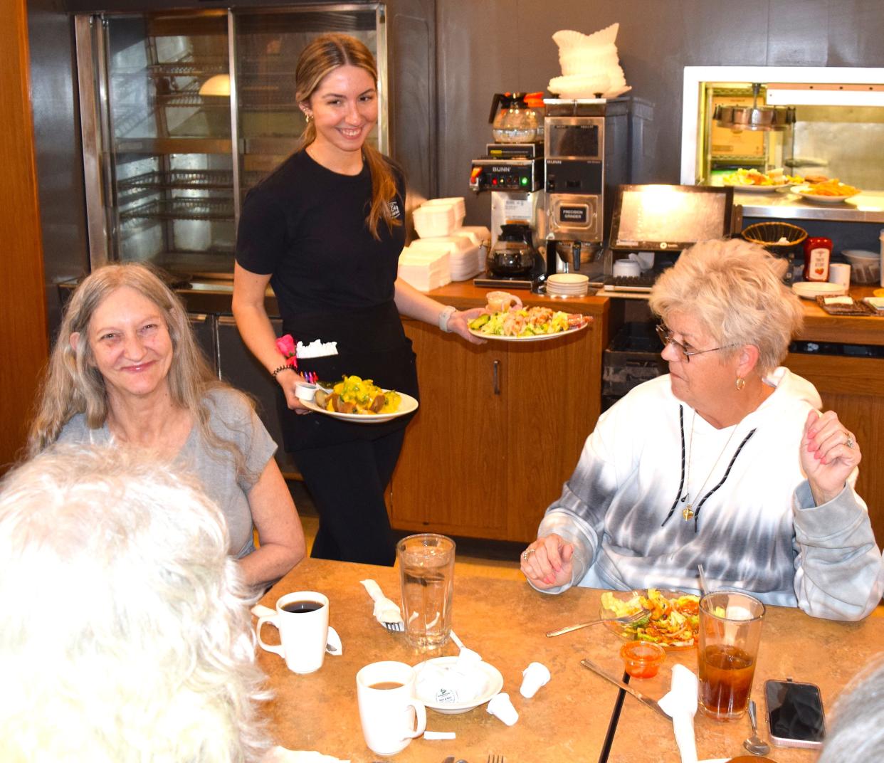 Madelynne McKelvey serves up meals to members of the Sprang family during a family reunion at Green Leaf Restaurant.