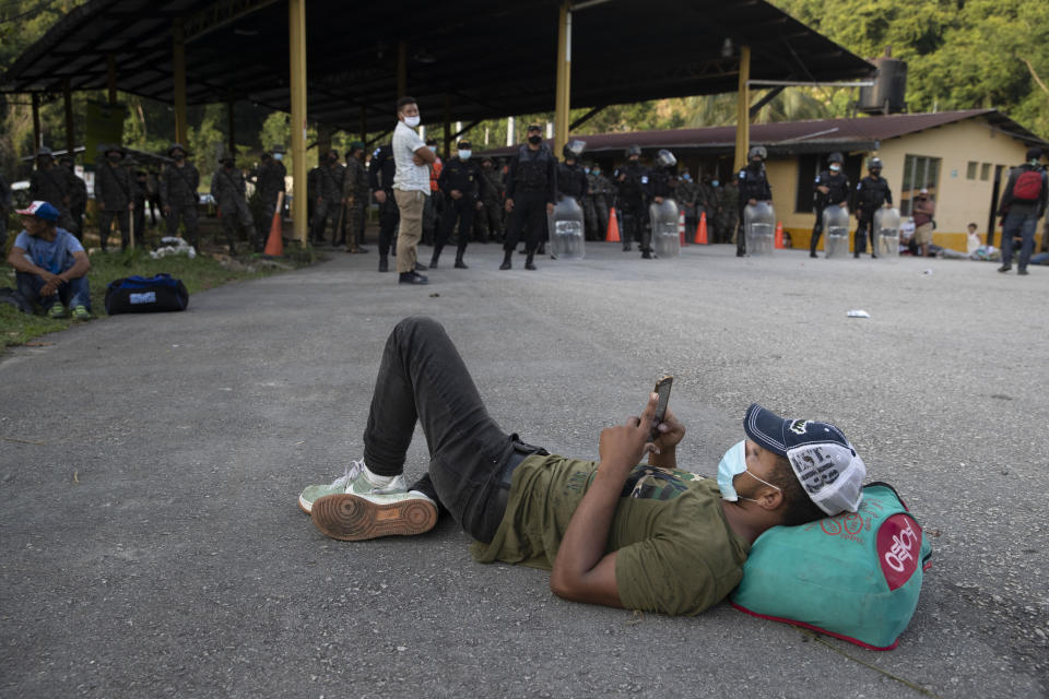 Un migrante hondureño descansa ante un bloqueo de carretera impuesto por las fuerzas de seguridad en Poptun, Guatemala, el 2 de octubre de 2020. (AP Foto/Moisés Castillo)