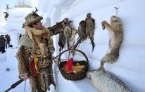 A man dressed as a herder hangs animal carcasses on the wall to decorate his snow house ahead of the 30th Harbin Ice and Snow Festival in Harbin, Heilongjiang province December 28, 2013. The festival kicks off on January 5, 2014. REUTERS/Sheng Li (CHINA - Tags: SOCIETY ENVIRONMENT ENTERTAINMENT) CHINA OUT. NO COMMERCIAL OR EDITORIAL SALES IN CHINA