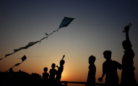 Young Rohingya refugees fly kites at the Hakimpara refugee camp  - Credit: AFP