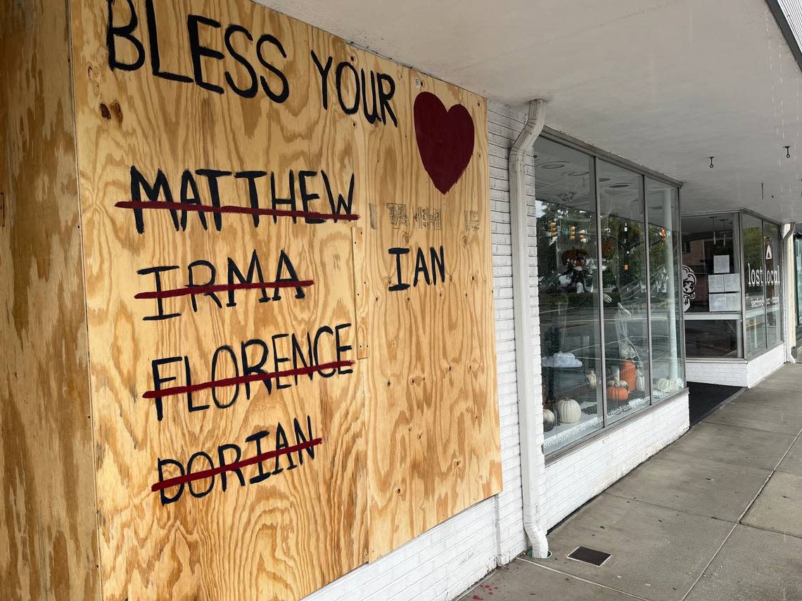 A board placed over the window of a shop on Bay Street in downtown Beaufort lists the names of previous hurricanes and the current one, Ian, approaching the South Carolina coast on Friday morning, Sept. 30, 2022.