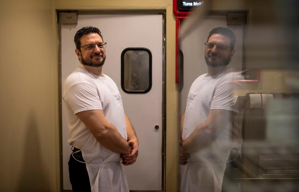 Demetre Keros, co-owner of Coney Town, smiles as he stands behind the counter of his business during lunchtime inside the Renaissance Center in Detroit on Wednesday, Feb. 28, 2024.