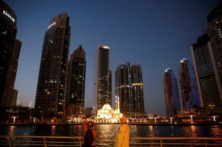 FILE PHOTO: Tourist take photos of a mosque across the Dubai Marina, surrounded by high towers of hotels, banks and office buildings, in Dubai, United Arab Emirates December 11, 2017. REUTERS/Amr Abdallah Dalsh