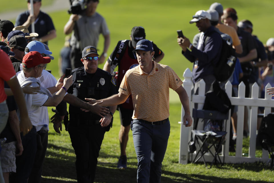Justin Rose, of England, greets fans as he makes his way to the 14th hole of the South Course at Torrey Pines Golf Course during the final round of the Farmers Insurance golf tournament Sunday, Jan. 27, 2019, in San Diego. (AP Photo/Gregory Bull)