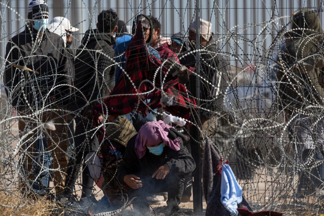 Male migrants are escorted south behind a barrier by the Texas National Guard on the Rio Grande in El Paso, Texas on March 21, 2024. The migrants were hoping to be processed by Border Patrol.