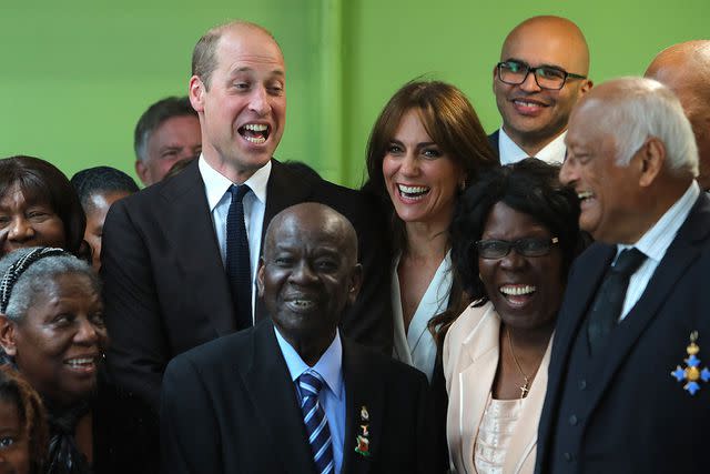 <p>GEOFF CADDICK/POOL/AFP via Getty Images</p> Prince William and Kate Middleton laugh with members from the Windrush Cymru Elders