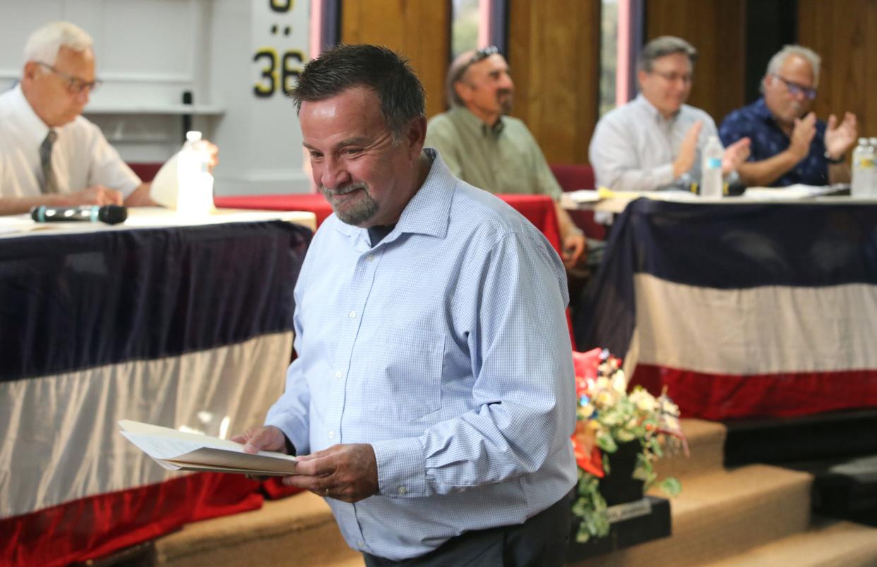 Rev. Ron Lanham of Turning Point Baptist Church walks away with documents signed by Lexington Township trustees. After renting its building for 10 years, the church signed the papers to buy the former Limaville Community Center.