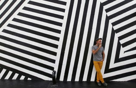 Rafael Alvarez smokes a cigarette outside a building in the Miami neighborhood of Wynwood October 8, 2014. REUTERS/Andrew Innerarity