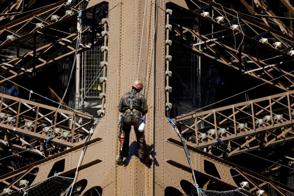 A worker is seen on the Eiffel tower during the 20th campaign of painting and stripping of the Eiffel tower in Paris, France (REUTERS)