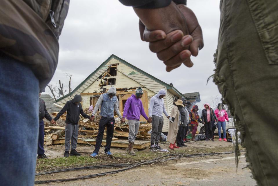 Residents of Talbotton, Ga. pray together outside a home destroyed by a tornado the day after storms battered Alabama and Georgia, March 4, 2019. (Photo: Grant Blankenship /The Macon Telegraph via AP)