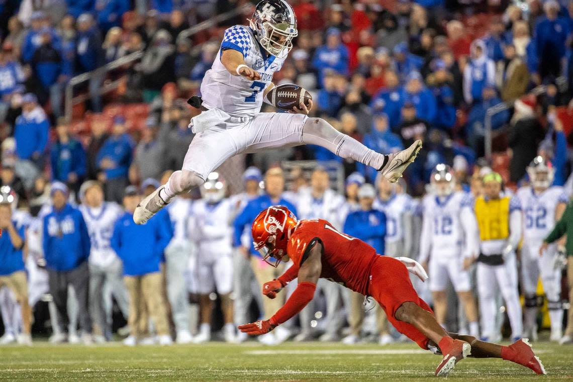 Kentucky Wildcats quarterback Will Levis (7) jumps over D*Louisville Cardinals defensive back Qwynnterrio Cole (12) during the GovernorÕs Cup at Cardinal Stadium in Louisville, Ky., on Saturday, Nov. 27, 2021. Ryan C. Hermens/rhermens@herald-leader.com