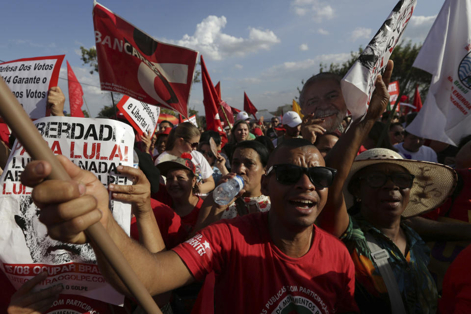 Supporters of Brazil's jailed, former President Luiz Inacio Lula da Silva march outside the Supreme Electoral Tribunal in Brasilia, Brazil, Wednesday, Aug. 15 2018. The Workers' Party registered the jailed former president as its candidate for president Wednesday, its latest attempt to muscle him into the race to lead Latin America's largest nation in a showdown with Brazilian electoral authorities. (AP Photo/Eraldo Peres)