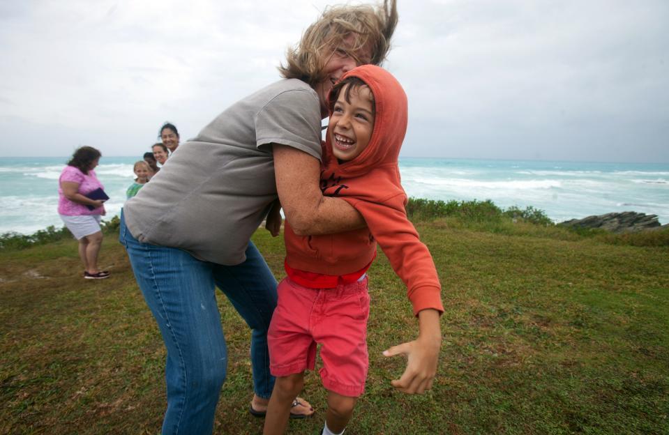 People stand on the island's south shore to feel the winds from approaching Hurricane Gonzalo, in Astwood Park, October 17, 2014. Hurricane Gonzalo barrelled toward Bermuda on Friday with damaging winds and a dangerous surge of water as one of the strongest storms to threaten the Atlantic islands, forecasters said. (REUTERS/Nicola Muirhead)