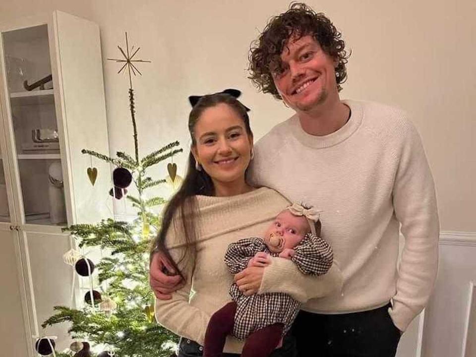 family in front of christmas tree