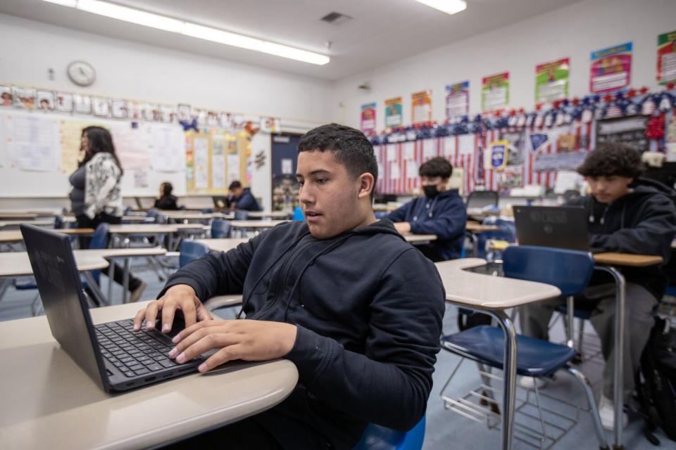 Students sit at classroom desks.