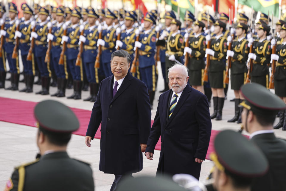 El presidente brasileño Luiz Inácio Lula da Silva, a la derecha, pasa revista a una guardia de honor con su homólogo chino Xi Jinping el viernes 14 de abril de 2023, durante una ceremonia de bienvenida frente al Gran Salón del Pueblo, en Beijing. (Ken Ishii/Foto compartida vía AP)