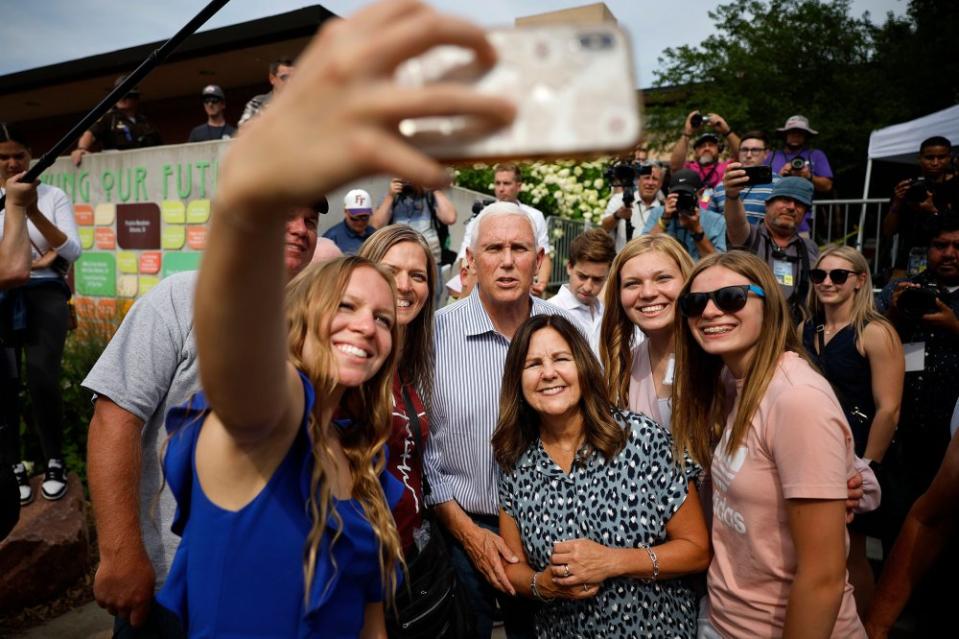 Republican presidential candidate former Vice President Mike Pence and his wife Karen Pence pose for selfies with supporters on Aug. 10.<span class="copyright">Chip Somodevilla—Getty Images</span>