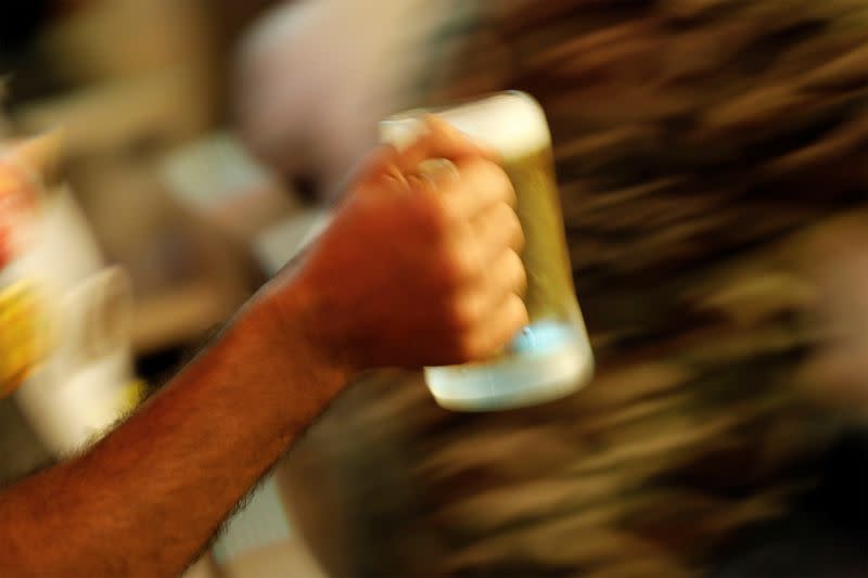 A waiter carries a beer mug at a pub in Mumbai