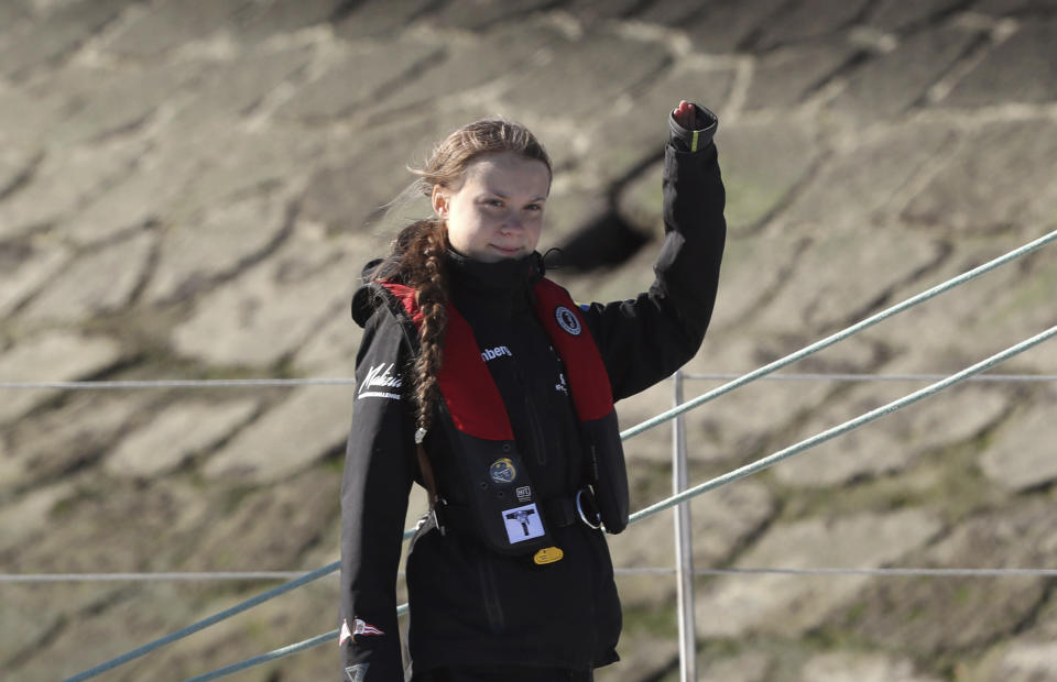 Climate activist Greta Thunberg waves as she arrives in Lisbon aboard the sailboat La Vagabonde Tuesday, Dec 3, 2019. Climate activist Greta Thunberg has arrived by catamaran in the port of Lisbon after a three-week voyage across the Atlantic Ocean from the United States. The Swedish teen sailed to the Portuguese capital before heading to neighboring Spain to attend the U.N. Climate Change Conference taking place in Madrid. (AP Photo/Pedro Rocha)
