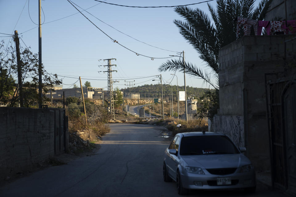 A security metal gate near an Israeli army post, closes the road at the main entrance of the West Bank village of Nabi Saleh, northwest of Ramallah, Thursday, Nov. 30, 2023. The release of Palestinian prisoners under the Israel-Hamas cease-fire agreement last week has touched nearly everyone in the occupied West Bank, where 750,000 Palestinians have been arrested since 1967. In negotiations with Israel to free hostages in Hamas captivity in Gaza, the militant group has pushed for the release of high-profile prisoners. But experts say most Palestinians passing through Israel's ever-revolving prison door are young men arrested in the middle of the night for throwing stones and firebombs in villages near Israeli settlements. (AP Photo/Nasser Nasser)