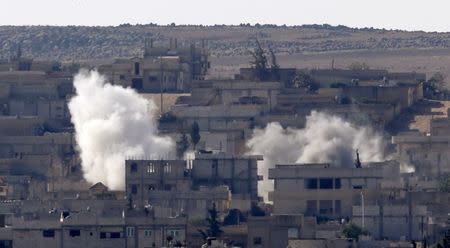 Smoke rises from the Syrian town of Kobani, seen from near the Mursitpinar border crossing on the Turkish-Syrian border in the southeastern town of Suruc, Sanliurfa province, October 5, 2014. REUTERS/Umit Bektas