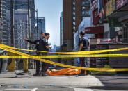 <p>Police officers stand by a covered body in Toronto after a van mounted a sidewalk and crashed into a crowd of pedestrians on Monday, April 23, 2018. (Photo: Aaron Vincent Elkaim/The Canadian Press via AP) </p>