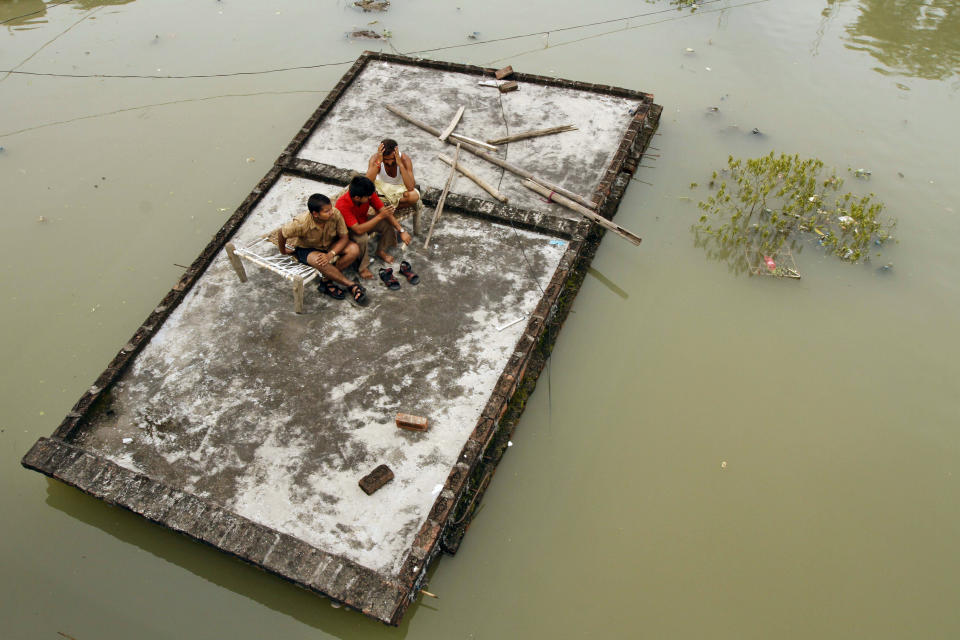 Indian men sit on the roof of a house which is submerged in the floodwaters of the River Ganges after heavy monsoon rains in Salori, India, Monday, Aug. 26, 2013. India's monsoon season, which runs from June through September, brings rains that are vital to agriculture but also cause floods and landslides. (Rajesh Kumar Singh/AP)