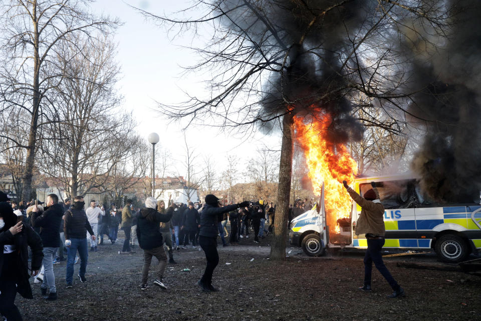 Protesters set fire to a police bus in the park Sveaparken in Orebro, Sweden, Friday, April 15, 2022. Police in Sweden say they are preparing for new violent clashes following riots that erupted between demonstrators and counter-protesters in the central city of Orebro on Friday ahead of an anti-Islam far-right group’s plan to burn a Quran there. (Kicki Nilsson/TT via AP)