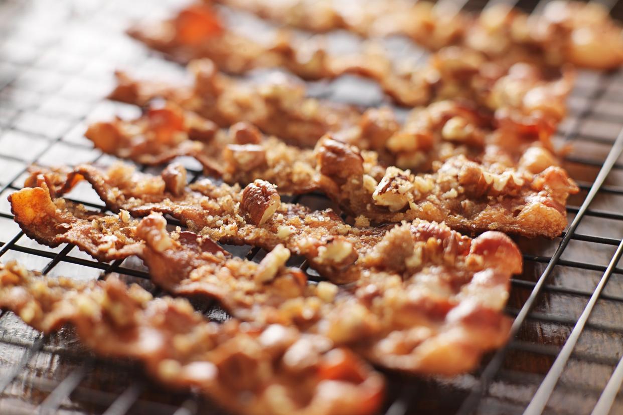 candied bacon with pecans and brown sugar cooling on baking rack