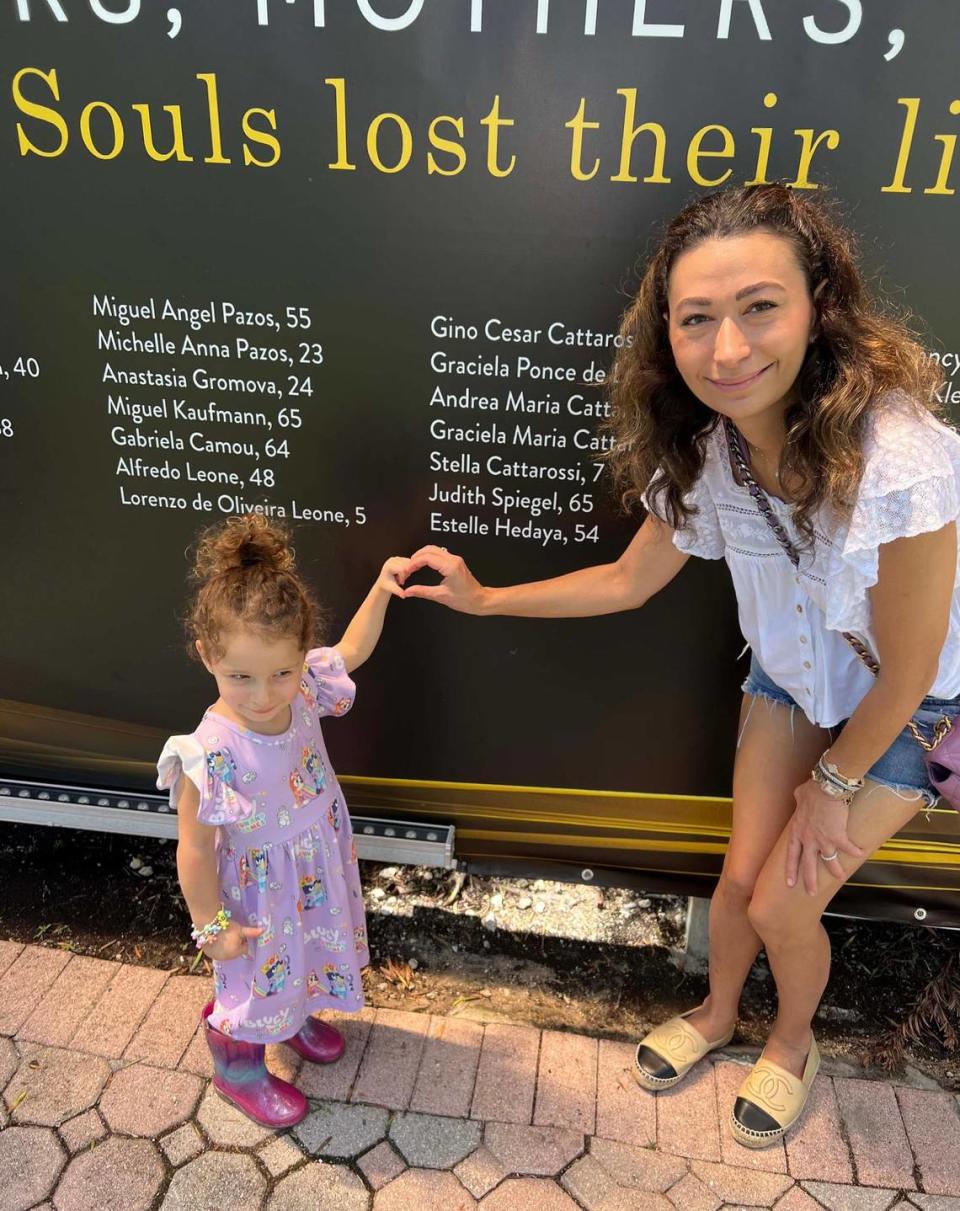 Rachel Spiegel and her daughter, Sloane, at the memorial wall at the site of the Champlain Towers South condo collapse in Surfside. Judy Spiegel, Rachel’s mother and Sloane’s grandmother, was one of the 98 people killed in the June 24, 2021 collapse.