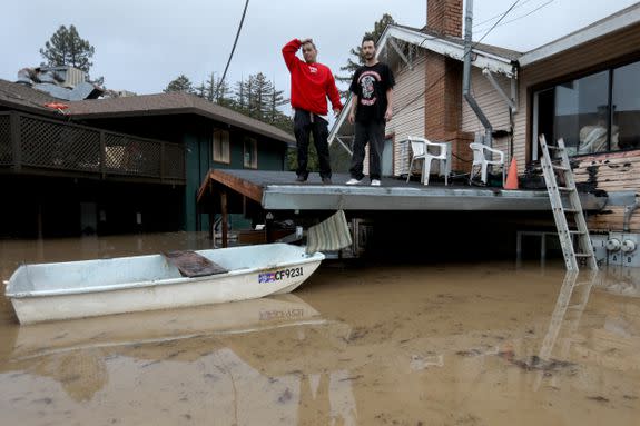 Residents stand on the rooftop of a home in Guerneville, California, preparing to evacuate after the Russian River flooded the town.