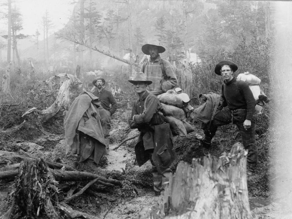 Photographic prints of four prospectors posed on a trail, Alaska. Dated 1897